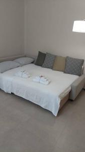 皮亚琴察Home 11的一张带白色床单和枕头的床