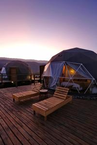 塔菲德尔瓦勒Glamping Tafí del valle的一组帐篷,位于带长凳的甲板上