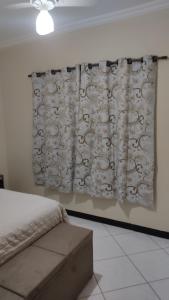 瓦拉达里斯州长市Casa bairro Tiradentes的一间卧室配有床,墙上挂着窗帘