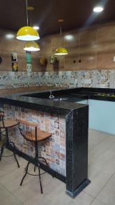 瓦拉达里斯州长市Casa bairro Tiradentes的一间带柜台的厨房和一间带椅子的酒吧