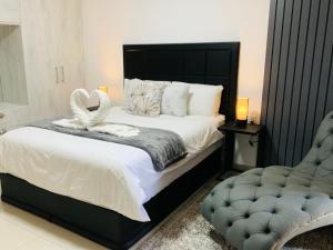 温特和克Essence Lifestyle Self-Catering Accommodation的一间卧室配有一张大床和一把椅子