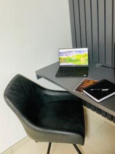 温特和克Essence Lifestyle Self-Catering Accommodation的一张桌子,椅子上配有一台笔记本电脑