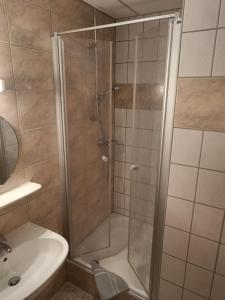 诺伊豪森皇冠高级酒店的浴室里设有玻璃门淋浴