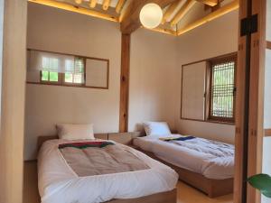 首尔IRIRU Luxury Hanok Stay - Eunpyung Hanok village的带2扇窗户的客房内的2张床