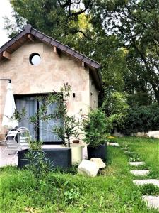 布瓦西圣雷热LE CHILL Suite & SPA (Jacuzzi et Sauna privés)的草丛中带椅子和植物的房子