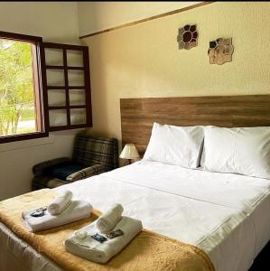 德尔芬莫雷拉hotel fazenda das montanhas的一间卧室配有一张大床和毛巾
