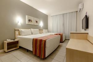 巴拉奈里奥-坎布里乌皮雷斯酒店的酒店客房设有两张床和一台平面电视。