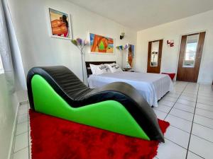 圣胡安Condado Beachfront Tantra Apartment的一间卧室配有一张带绿色沙发的床