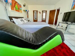 圣胡安Condado Beachfront Tantra Apartment的一间卧室配有一张床和一张绿色沙发
