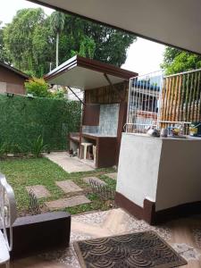 巴科洛德FAST Wifi 400 Mbps Tiny House in Bacolod City的庭院里设有桌子和长凳