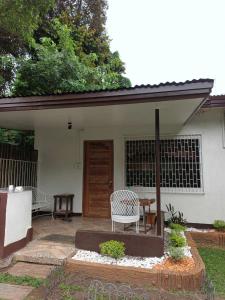 巴科洛德FAST Wifi 400 Mbps Tiny House in Bacolod City的房屋前设有带桌椅的天井。