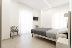 泰尔莫利Appartamento comfort-relax的白色卧室配有床和椅子