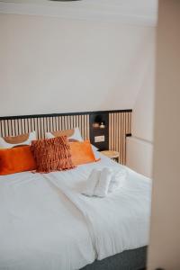 卡德赞德Bruist的一张带橙色和白色枕头的床