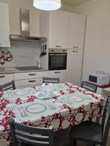 瓦拉泽Appartamento centralissimo,a 20 mt dal mare的厨房配有一张带红白桌布的桌子