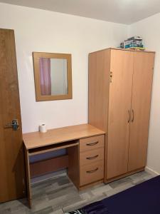 朴次茅斯Room in the centre of Portsmouth的一间带木制书桌和镜子的浴室