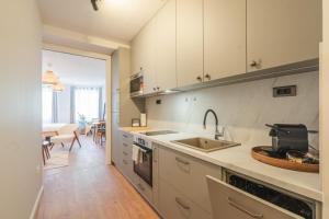 萨格勒布Apartment OLIVIA的厨房配有白色橱柜和水槽