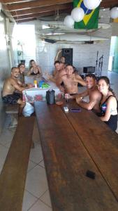 帕罗卡Gênesis Beach Hostel! Quartos compartilhados e privativos na Pinheira的一群坐在一张大桌子周围的男人