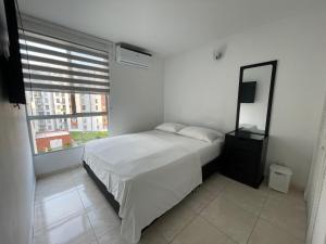 JamundíHermoso y comodo apartamento con Aire acondicionado y parqueo privado en unidad residencial - Jamundi的一间卧室配有一张床、镜子和窗户