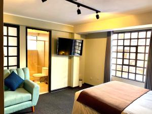 库斯科Apartamentos Montes的一间卧室配有一张床、一张沙发和一台电视。