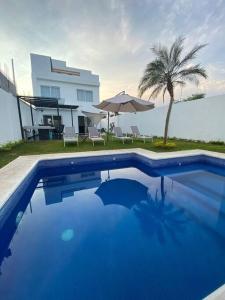 特克塞丁戈Hermosa casa familiar de fin de semana en Teques的一座大蓝色游泳池,位于房子前