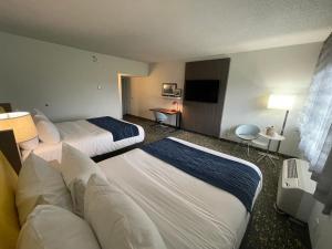 圣路易斯Saint Louis Airport Hotel的酒店客房设有两张床和一台平面电视。