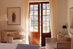 莫纳奇尔阿尔穆尼亚山谷酒店的卧室设有通往窗户的门