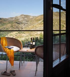 莫纳奇尔阿尔穆尼亚山谷酒店的阳台上的桌子上摆放着葡萄酒