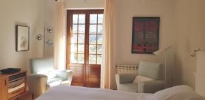 莫纳奇尔阿尔穆尼亚山谷酒店的一间卧室配有两把椅子、一张床和窗户
