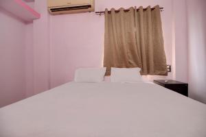 KorādihSuper OYO Hotel Elite Inn的窗户客房内的一张白色床