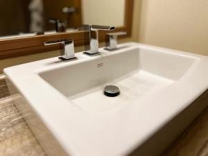 Carmacks卡马克斯酒店的浴室内带两个水龙头的白色水槽