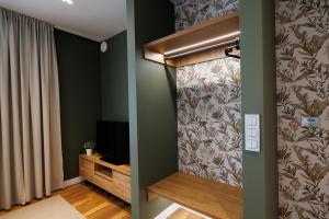 华沙B85 Suites的客厅设有绿色的墙壁和电视。
