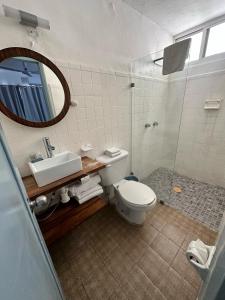 马萨特兰Creta Hotel & Suites的一间带卫生间、水槽和镜子的浴室