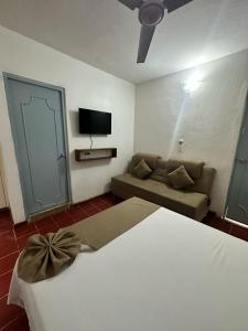 马萨特兰Creta Hotel & Suites的酒店客房,配有床和沙发