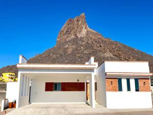 圣卡洛斯CASA SAHUARO con alberca privada, Col El Mirador的一座白楼,背景是一座山