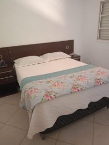 戈亚斯州上帕莱索Conexão Hostel的一间卧室,床上放着鲜花