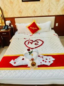 Ðông KhêKhách Sạn Nam Sơn的一张拥有红色和白色装饰的床