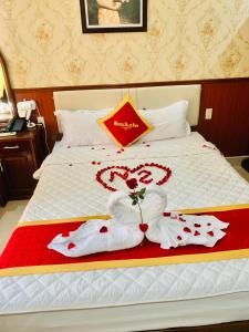 Ðông KhêKhách Sạn Nam Sơn的一张用毛巾制成的两颗心的酒店床