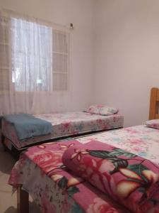 戈亚斯州上帕莱索Conexão Hostel的窗户间里设有三张床