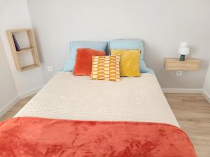 阿尔蒂盖普雷博尔多Paisible, spacieux avec petit jardin的一张床上有色彩缤纷的枕头