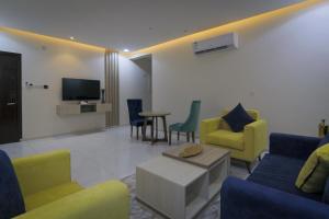 艾卜哈جراند فيوتشر的客厅配有黄色和蓝色的椅子和电视