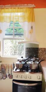 "SunRise Inn" Nature Island Dominica的带窗户的厨房内的2个炉灶
