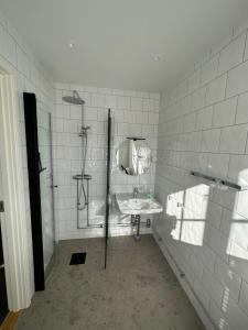 斯特伦斯塔德Crusellska Vandrarhemmet的白色瓷砖浴室设有水槽和淋浴