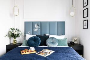 华沙Luxury Design Apartments - Warsaw Tower Bliska Wola的一间卧室配有一张蓝色的床,上面有盘子的食物