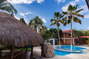 瓜杜阿斯VILLA JULIETA CABAÑA 1的一个带游泳池和棕榈树的度假村