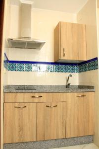 科尔多瓦Apartamentos Medina Qurtuba的一个带木制橱柜和水槽的厨房