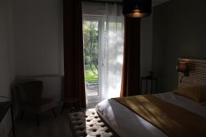 伊芙尔莱韦克Le pré du buis的一间卧室设有一张床、一个窗口和一把椅子
