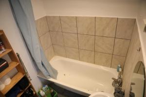 里尔Appartement spacieux Lille的浴室配有白色浴缸和水槽