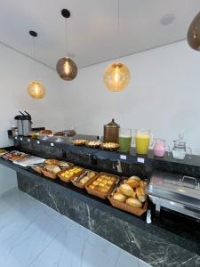 阿帕雷西达Hotel Pousada Colliseu的包含多种不同种类甜甜圈和饮料的自助餐