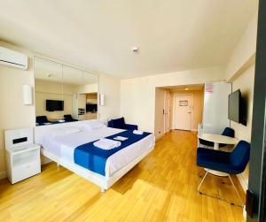 巴统Luxury Aparthotel orbi in black sea arena的一间卧室配有一张大床、一张桌子和一把椅子