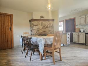 朗福德Longford Holiday Red Rose Self Catering Cottage的厨房配有一张桌子和椅子,厨房设有石墙